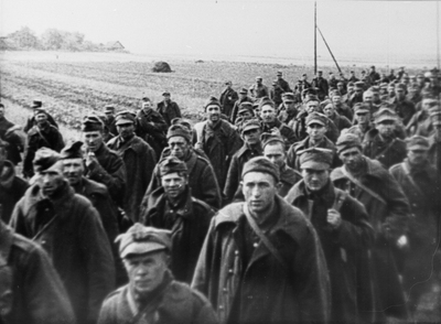 Kolumna jeńców polskich maszerujących polną drogą pod eskortą żołnierzy sowieckich